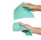 Hand holding green microfiber chamois isolated on white background. Clipping path. Microfiber use for cleaning. Multi Purpose