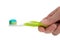 A Hand holding a Green toothbrush on white