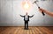 Hand holding a hammer going to break glowing bulb over businessman\'s head.