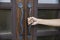 Hand holding handle of wood door