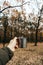 Hand holding an iron cup with a hot drink on a background of autumn forest. vertical photo. mood of adventure and