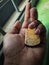 A hand holding a keychain made of wood