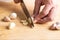 Hand holding kitchen knife and chopping garlic