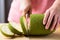 Hand holding kitchen knife and cutting young jackfruit