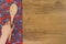 Hand holding kitchen wood spoon. Pattern flower cloth napkin on