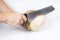 Hand holding knife with coconut peeling on white background