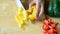 Hand holding knife and cutting yellow bell pepper