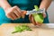Hand holding knife and peeled green mango