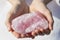 A hand holding a large piece of Rose Quartz