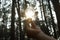 hand holding light bulb with sunlight in forest. solar energy, clean power