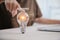 Hand holding light bulb with virtual graduate icon. E-learning education graduation concept, smart learning online with brainstorm