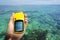 Hand holding a marine GPS navigator over the sea