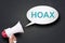 Hand Holding Megaphone with Hoax Word in Speech Bubble