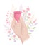 Hand Holding A Menstrual Cup On A Flowers Background