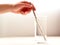 Hand holding a metal straw in a glass of water