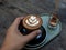 Hand holding mocha coffee on wooden table background