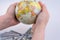 Hand holding a model globe by the side of American dollar bankn