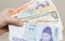 A hand holding money banknotes of different countries: Korean won, Russian rouble, Dollar USA, Chinese RMB yuan and ukraine grivna