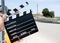 Hand holding movie slate on defocused motor sport asphalt track circuit