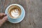 hand holding a nearly empty cup of cappuccino coffee