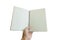 Hand holding opened notebook, isolated on white background