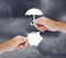 Hand holding a paper piggy bank and umbrella