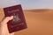 Hand holding a passport in the desert of Saudi Arabia