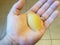 Hand holding pasta shell over tile floor