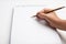 hand holding pen writing on blank white paper. Hand write in the white blank sheet