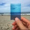 Hand holding photo of beach