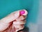 Hand Holding Pink Medication Pill with Selective Focus