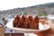 Hand holding a plate of chocolate cake against blurry city aerial view