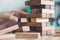 A hand holding and playing Jenga or Tumble tower wooden block game