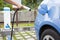 Hand holding plug for Charging of an electric car in parking spa