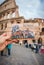 Hand holding postcard with Colosseum print in Rome street