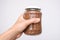 Hand holding a pot of buckwheat agaonst white background, national russian food symbol of crisis and economy, food