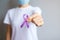 Hand holding purple Ribbon for Pancreatic, Esophageal, Testicular cancer, world Alzheimer, epilepsy, lupus, Sarcoidosis,