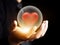 Hand holding red heart in crystal ball