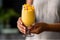 hand holding refreshing mango cocktail in tall glass. AI Generative