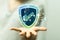 Hand holding a render of a green blue cybersecurity shield