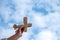 A hand holding and rising a wooden airplane into blue sky