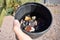 Hand Holding Rock Tumbler Barrel Full of Assorted Polished Stones