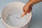 Hand holding rolling paint brush putting into white color bucket