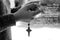Hand holding rosary beads with Jesus Christ holy cross crucifix with Salam Maria prayer text translated in Bahasa Indonesia.
