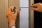 Hand holding screwdriver. Woman repairing door handle close up. Women home service concept. Do it yourself