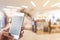 Hand holding smart phone with blurred shopping mall background