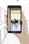 Hand Holding Smart Phone Displaying Photo of House Hallway Drawing Behind