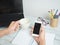 Hand holding smartphone and coffee cup with workspace on white wood table background,Phone and bitcoin in hand and laptop notebook