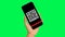 Hand holding a smartphone with a QR code reading on the screen, green background, chroma key, mockup. qr code scan on mobile phone