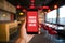 Hand holding smartphone showing ORDER FOOD ONLINE app with blurred restaurant ambiance